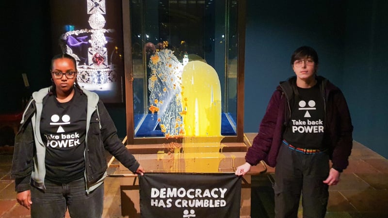 Skandál v Británii: Aktivisté zaútočili pudinkem na královskou korunu, ukazují záběry